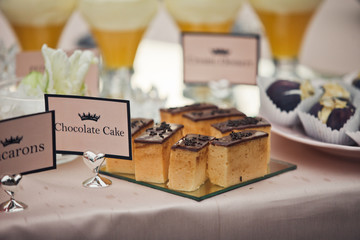 Cut chocolate cake stands on mirror tray on beige tablecloth