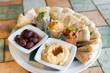Pita bread slices served with hummus and pates