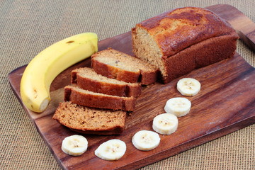 Fototapeta na wymiar Homemade banana cake with sliced banana and knife on butcher served