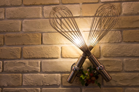 Whisk lamp on brick wall