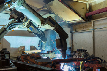 Robot welding automotive part in factory