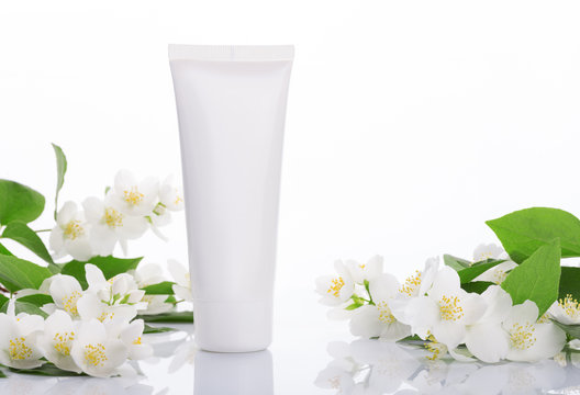 empty tubes of cream on a white background with flowers
