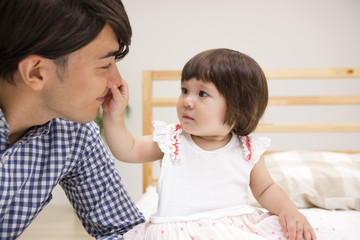 ベッドで遊ぶ家族