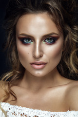 Obraz premium Beautiful woman portrait on black background with colorful eyeshadow and curly hair. 