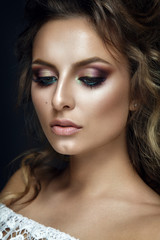 Obraz premium Beautiful woman portrait on black background with colorful eyeshadow and curly hair. 