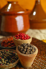 Dried red, hot chili, black, white peppers in old clay bowls 