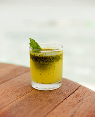 glass of fresh juice or cocktail on table at beach