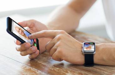 close up of hands with smart phone and watch