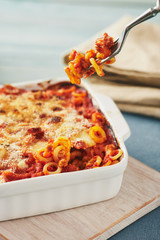 Baked anelletti pasta with mince, sauce and mozzarella. Typical sicilian dish