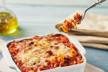 Baked anelletti pasta with mince, sauce and mozzarella. Typical sicilian dish
