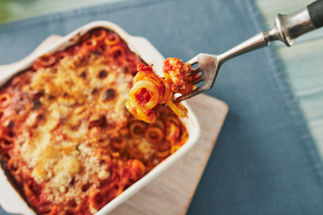 Baked anelletti pasta with mince, sauce and mozzarella. Typical sicilian dish