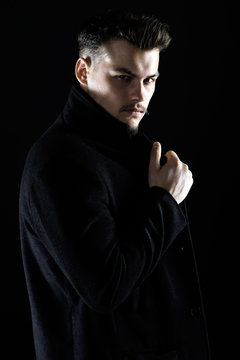 Studio Portrait of a Handsome Young Man in Black Suit