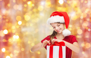 smiling girl in santa hat with christmas gift