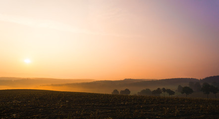 tiefstehende Sonne mit Nebel in den Tälern