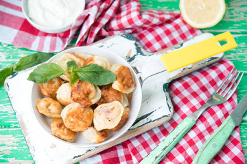Plate of fried pelmeni with cheese
