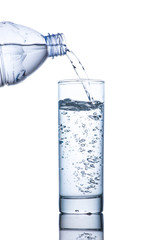 Drinking water is poured into a glass from bottle