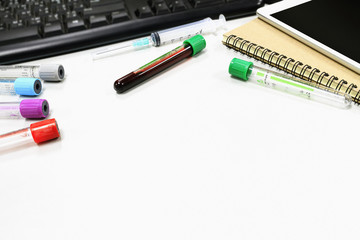 workspace. vacuum tubes for collecting blood samples on white table, over light [blur and selective...