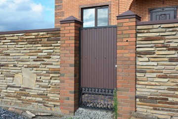 Installation of Stone  Fence with Metal Door