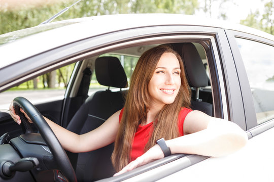 Young woman in red dress sitting in the car