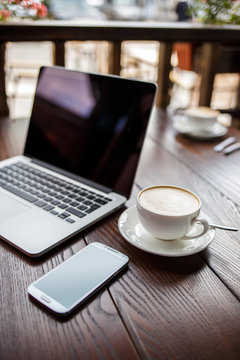 Mockup image with laptop, coffee and phone in cafe