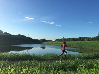 Male runner on path around lake
