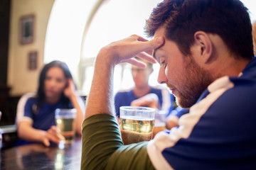 soccer fans watching football match at bar or pub