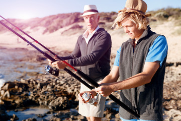 Obraz premium Senior man fishing with his grandson