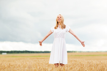 Fototapeta na wymiar smiling young woman in white dress on cereal field