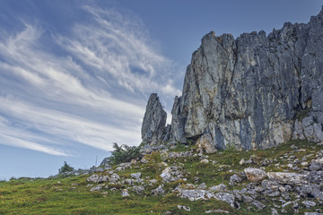 Alpine scenery with steep vertical rock cliff up in Magura Village, Brasov county, Romania.