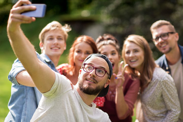 friends taking selfie by smartphone at summer