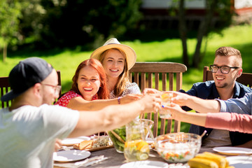 happy friends having dinner at summer garden party