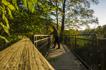 Mann hält beim Spazierengehen auf einer Brücke inne