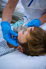 Nurse placing an oxygen mask on the face of a patient