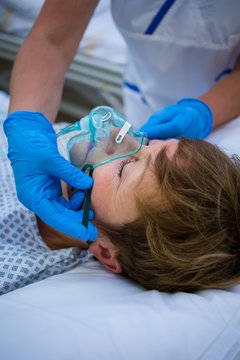 Nurse Placing An Oxygen Mask On The Face Of A Patient