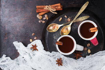 Hot chocolate in mug with spices on grunge dark table