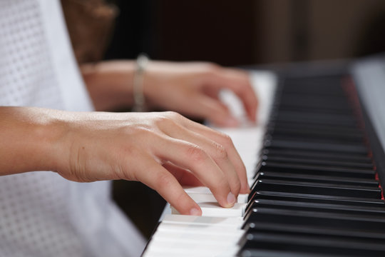 female's  hands playing piano