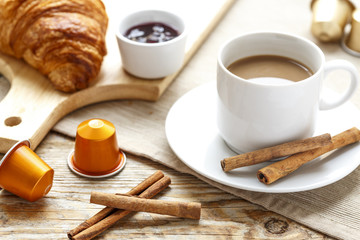 Breakfast with coffee, crackers and croissants on wooden table