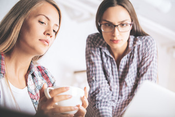 Attractive businesswomen using laptop together