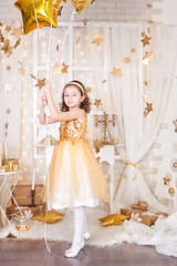 Fototapeta na wymiar Little girl in a gold Christmas decorations