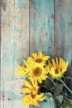 Background with a bouquet of yellow sunflowers on old wooden boa