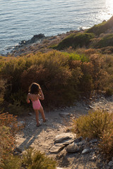 Naklejka premium Fillette en maillot de bain marchant sur un sentier vers la mer