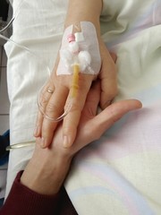 Hands of two people in the hospital. Close-up.
