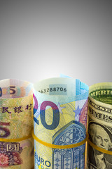 Roll of american dollar bill, five yuan and twenty euro