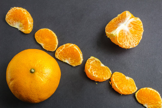 Orange mandarin or tangerine fruit on black background
