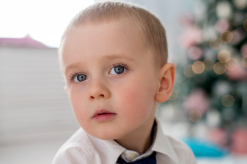 Portrait of a boy 3-4 years against a background of Christmas lights