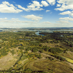 Fototapeta na wymiar Panoramic view of the Kiev suburb from above. Aerial view. Outdoor. Beautiful photos of nature with fields river and reservoirs with high-rise buildings in the background.