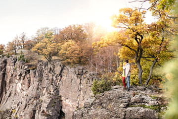 Naklejka premium Beautiful couple in autumn nature against colorful autumn forest