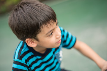 Little boy riding bicycle on the road around the house