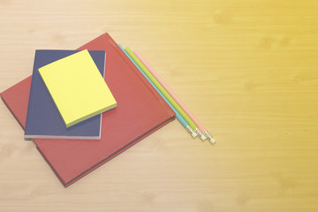 office desk with  book, note and pencil on wooden desk