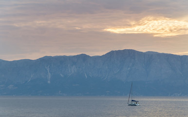 Obraz na płótnie Canvas Boat at sea with mountains
